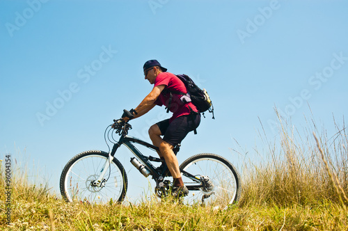 Bicycler against blue sky