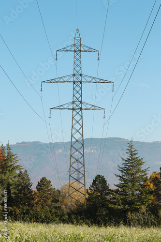 metal poles for power lines in a field outside the city in the summer day. industrial construction.