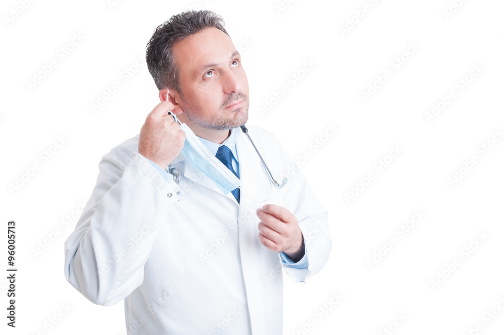 Handsome doctor removing protective surgical mask Handsome doctor removing protective surgical mask