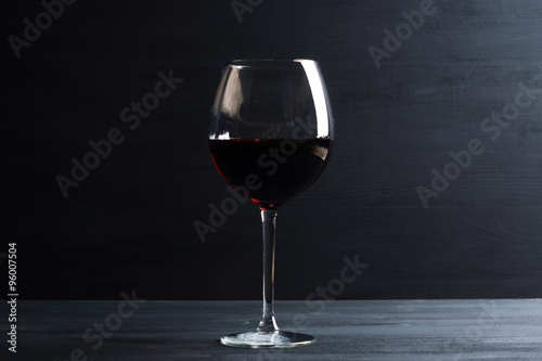Glass of wine on dark wooden background