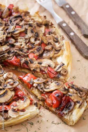 closeup of mushroom pizza with red sweet pepper on cooking paper. Vertical image.