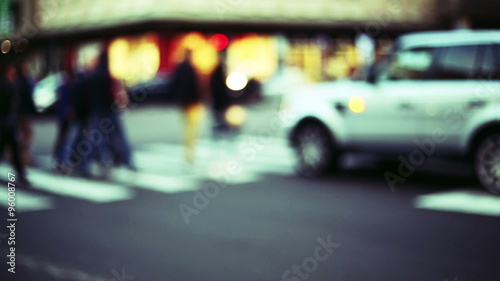 anonymous crowd cross the street into the traffic, blurred and out of focus context photo