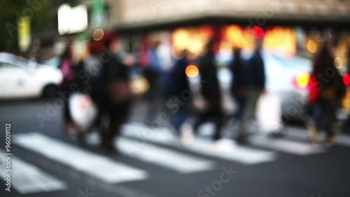 anonymous crowd cross the street in a city context with blurred and out of focus background photo