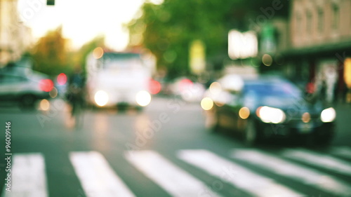 slow motion of a anonymous  biker riding into the traffic city in blurred and out of focus context photo