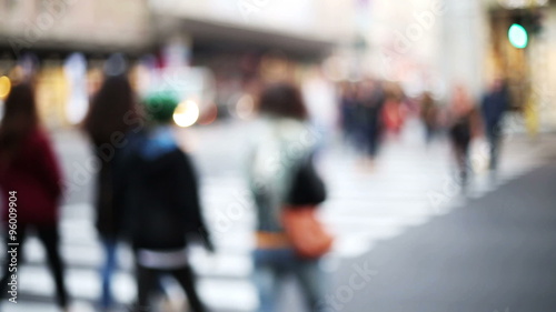 anonymous crowd cross the street in urban context blurred and out of focus photo