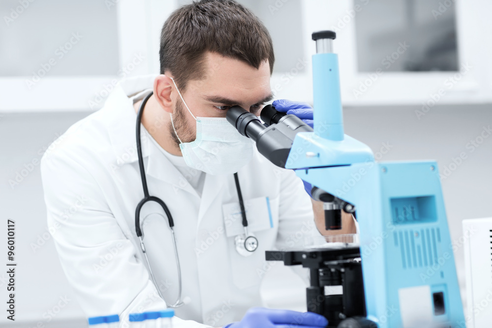 young scientist looking to microscope in lab young scientist looking to microscope in lab