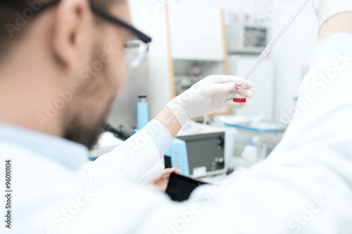 close up of scientist with tube and pipette in lab