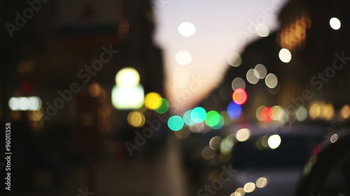 people walking in the street at the sunset  in  a out of focus and blurred background context city with lights and colors photo