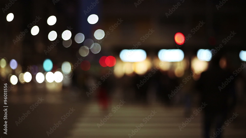 anonymous defocused people cross the street in a out of focus background with lights and colors in big city anonymous defocused people cross the street in a out of focus background with lights and colors in big city