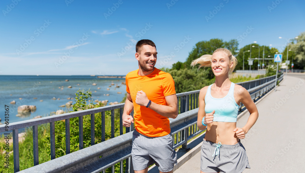 smiling couple running at summer seaside