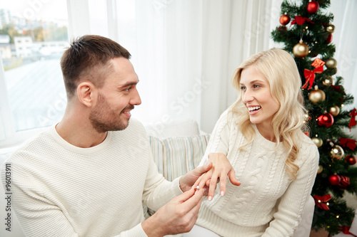 man giving engagement ring to woman for christmas