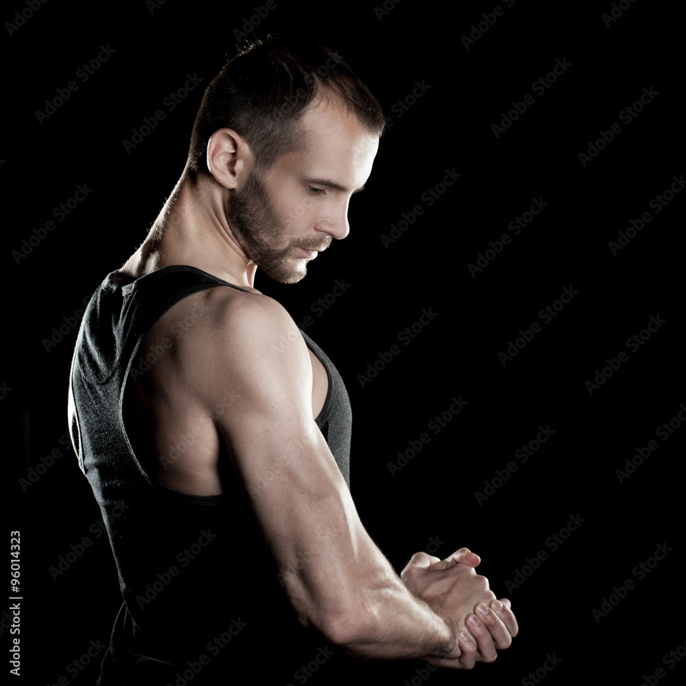 muscular man, clasps hands in fist, black background muscular man, clasps hands in fist, black background