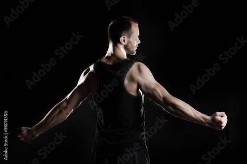 muscular man, black background, place for text on the right
