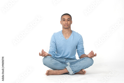 Young man in casual sitting in the lotus position over white background