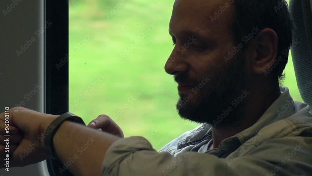 Young man with smartwatch sitting on a train, super slow motion, shot at 240fps Young man with smartwatch sitting on a train, super slow motion, shot at 240fps