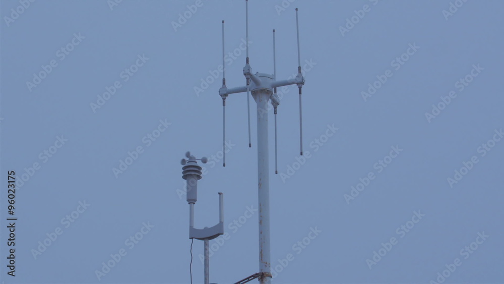 An anemometer on a tower in a small port. An anemometer is a device used for measuring wind speed and is a common weather station instrument. An anemometer on a tower in a small port. An anemometer is a device used for measuring wind speed and is a common weather station instrument.