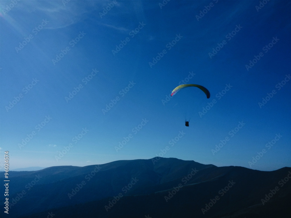 Man fly on paraglider above the mountains Man fly on paraglider above the mountains