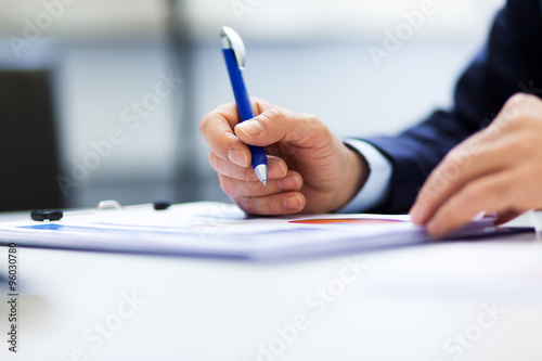     Closeup of a businessman s hand while writing some documents 