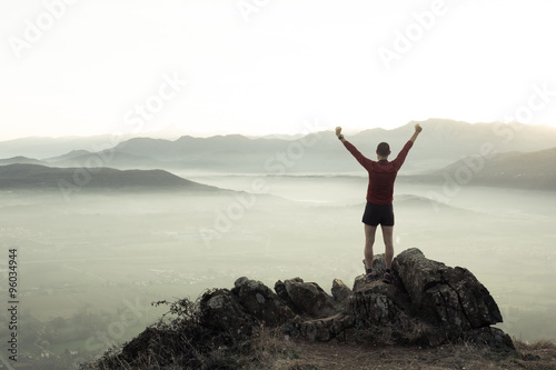 Man at the top of a mountain looking the landscape photo