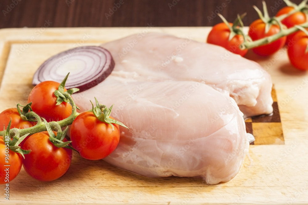 Fresh raw chicken breast with cocktail tomato Fresh raw chicken breast with cocktail tomato