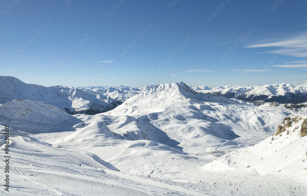 Winter Alpine mountains panorama snow slope with skiing and snowboarding people