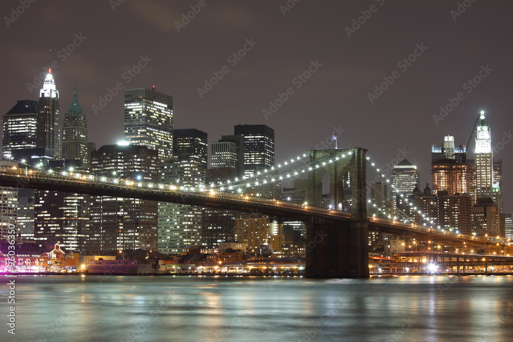 The Brooklyn Bridge and Manhattan skyline as seen from across the East River at dusk.