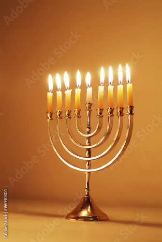 Brightly Lit Hanukkah Menorah on a Warm Gold Background