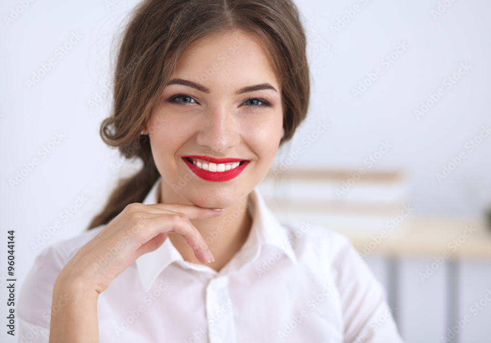 Attractive young businesswoman sitting in the office Attractive young businesswoman sitting in the office