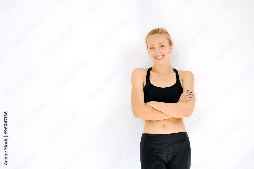 Smiling sporty woman portrait with crossed arms against white wa Smiling sporty woman portrait with crossed arms against white wa