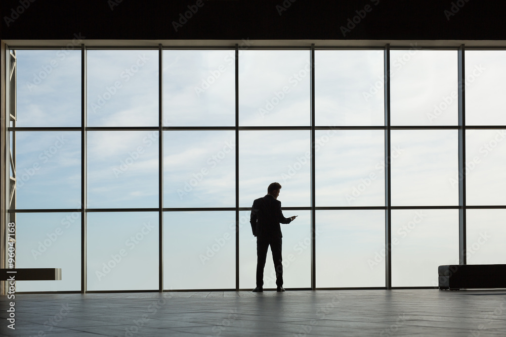Stylish business man in the background of a large window Stylish business man in the background of a large window