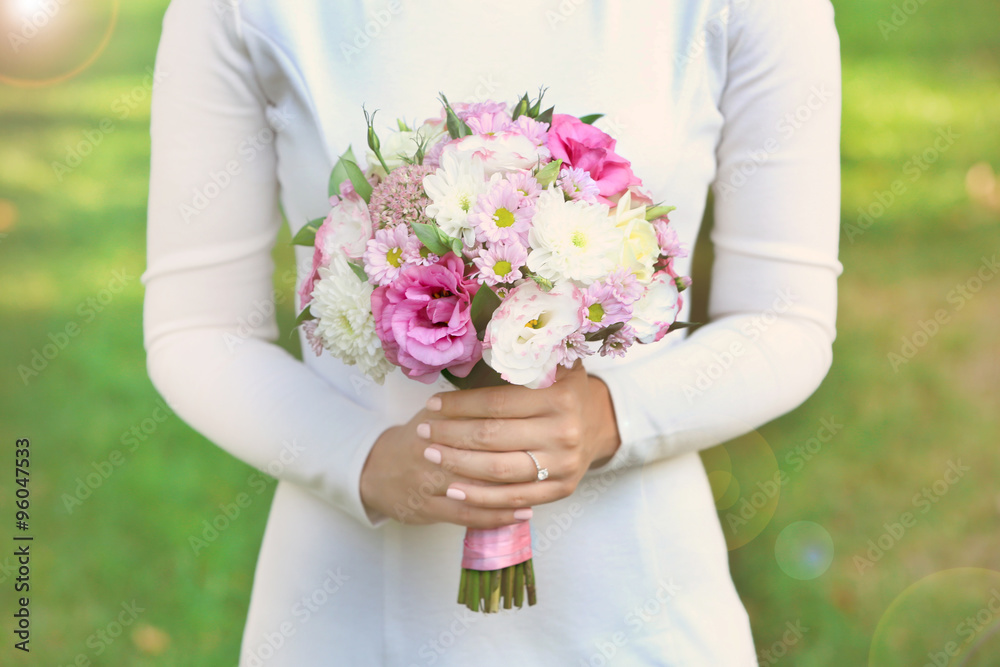 Beautiful wedding bouquet in hands of bride on nature background Beautiful wedding bouquet in hands of bride on nature background
