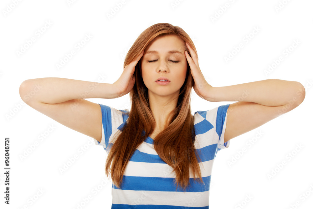 Teenage woman with headache holding her hand to the head