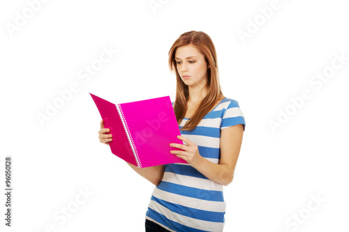 Young smiling teenage woman holding books