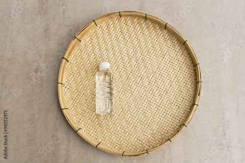 Obraz na plátně Plastic water bottle with basketry on the polished stone table - Small water bot
