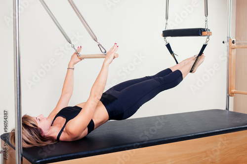 Pilates aerobic instructor woman in cadillac fitness exercise photo