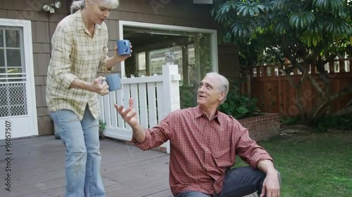 Happy senior couple enjoying a morning cup of coffee outdoors