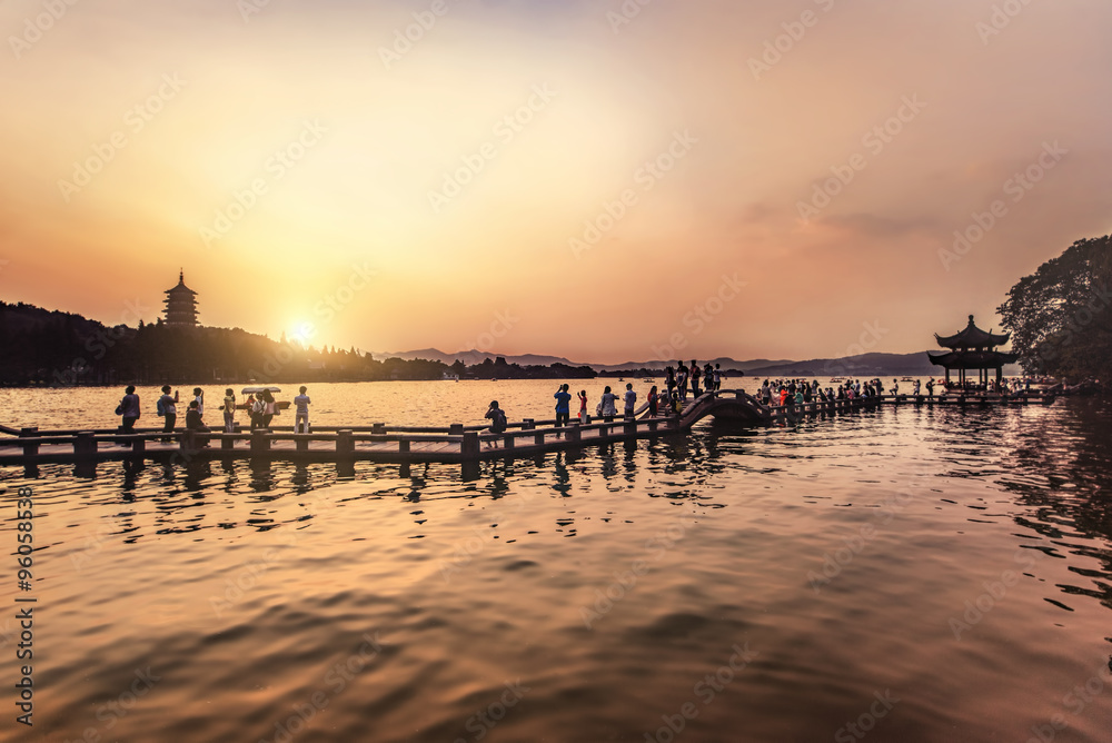 beautiful hangzhou in sunset, ancient pavilion silhouette on the