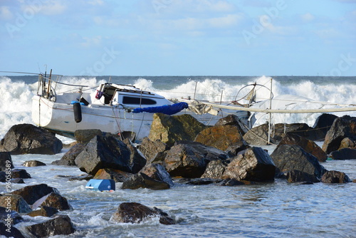 A Yacht being ship wrecked on the rocks on the beach at San Diego, California 