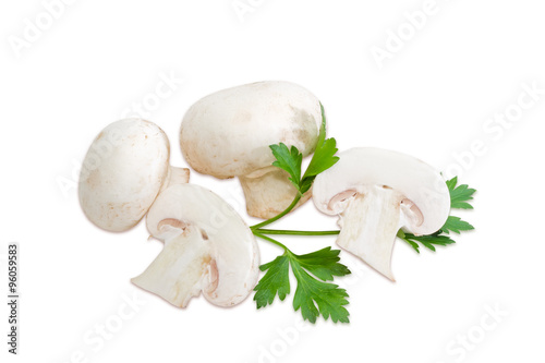 Several champignon mushroom and a leaf of parsley