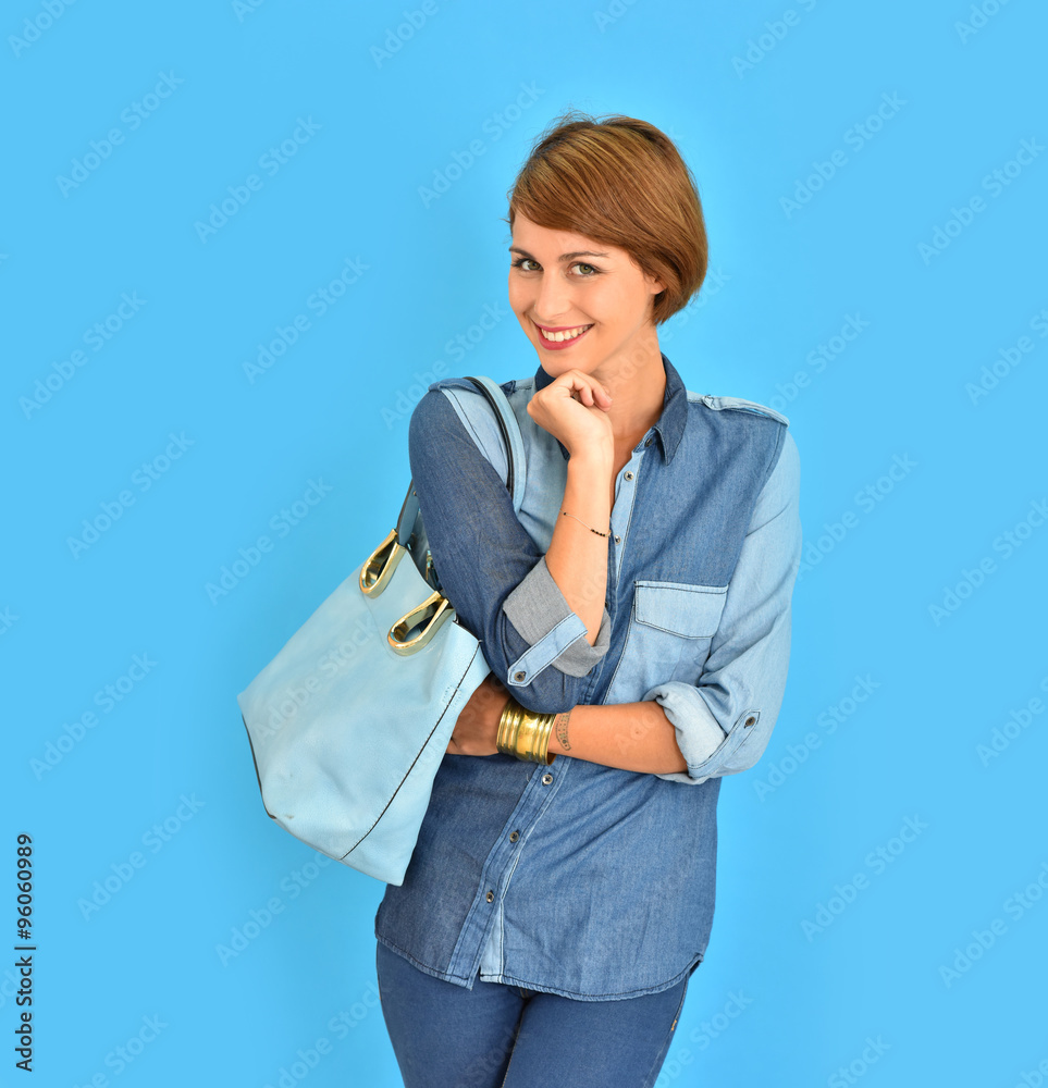 Smiling attractive girl standing on blue background Smiling attractive girl standing on blue background