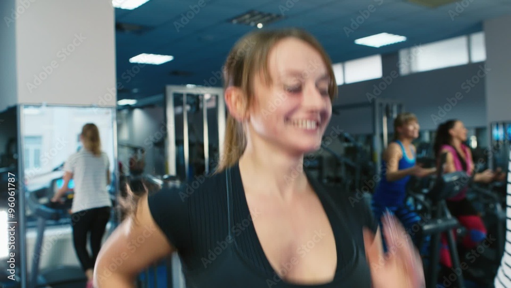 Attractive woman training on a treadmill, smiling Attractive woman training on a treadmill, smiling