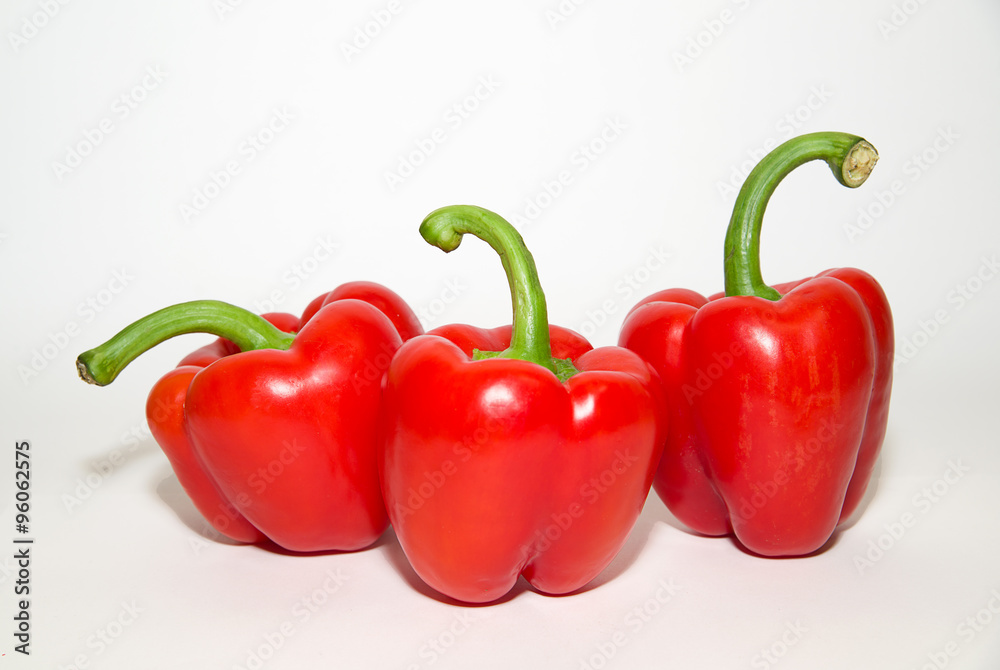 Three ripe red peppers on over white Three ripe red peppers on over white