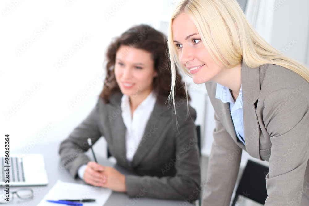 A group of business people at a meeting on the background of office. Focus on a beautiful blonde A group of business people at a meeting on the background of office. Focus on a beautiful blonde