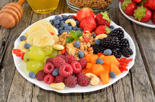 ingredients for a healthy breakfast - berries  fruit and muesli on wooden table  close-up  horizontal