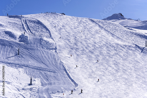 Ski slope on Hinterux glacier in Austrian Alps with skiers, snowboarders and snow lances. photo