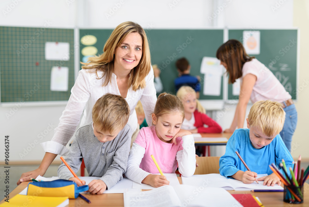 freundliche lehrerin mit kindern in der grundschule freundliche lehrerin mit kindern in der grundschule