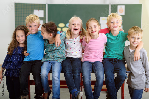 Photography lachende kinder in der grundschule sitzen auf dem tisch