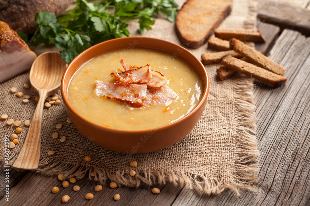 Traditional german homemade pea soup recipe with bacon and croutons in clay dish on vintage wooden table background. Tasty national food Traditional german homemade pea soup recipe with bacon and croutons in clay dish on vintage wooden table background. Tasty national food