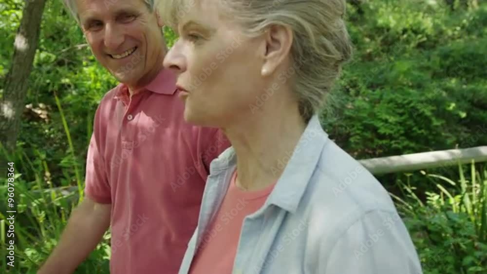 Beautiful mature couple walking together through the countryside Beautiful mature couple walking together through the countryside