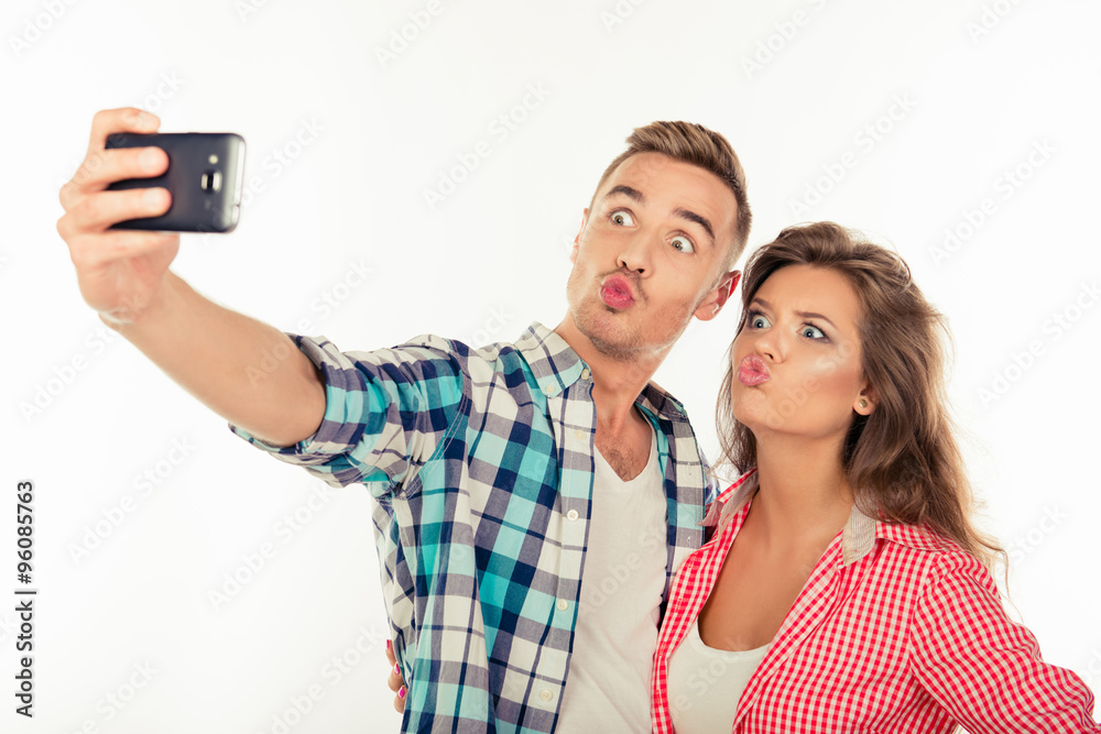 Cheerful funny couple in love making selfie photo with smartphon Cheerful funny couple in love making selfie photo with smartphon